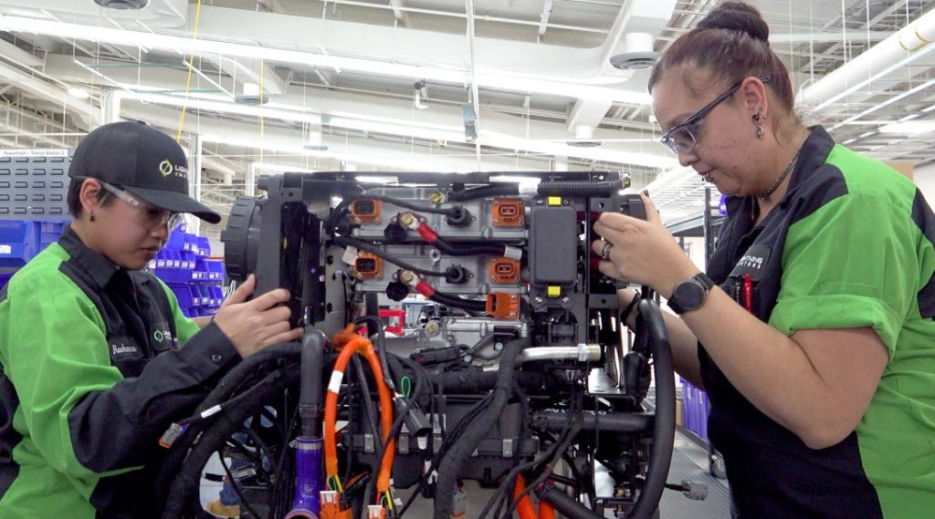 Two Lightning eMotors production technicians assemble a powertrain for an electric vehicle - Tim Reeser