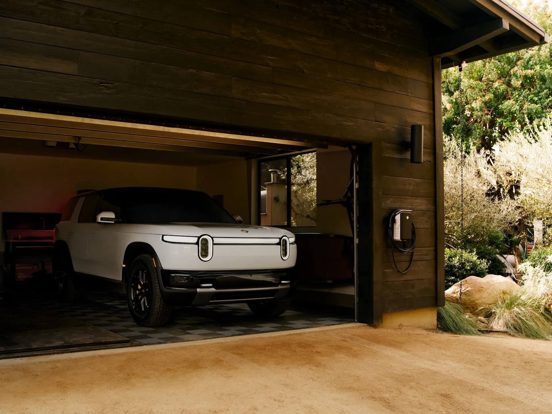 A Rivian R2 charging at home, managed by ChargeScape's vehicle-grid integration platform