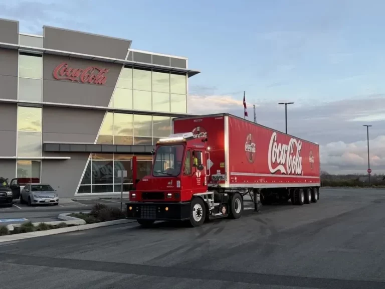 Orange EV electric terminal truck — the company's 2,000th unit — deployed to Coke Canada Bottling