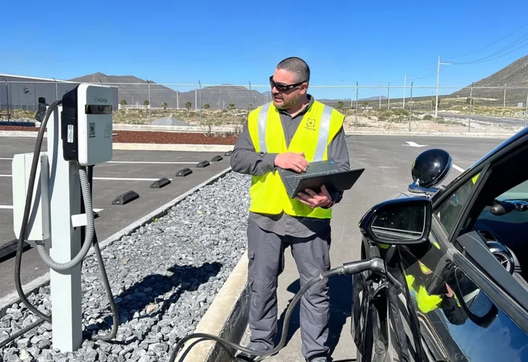 InCharge Energy technician holding a laptop beside an EV charger after the company's $46 million funding round