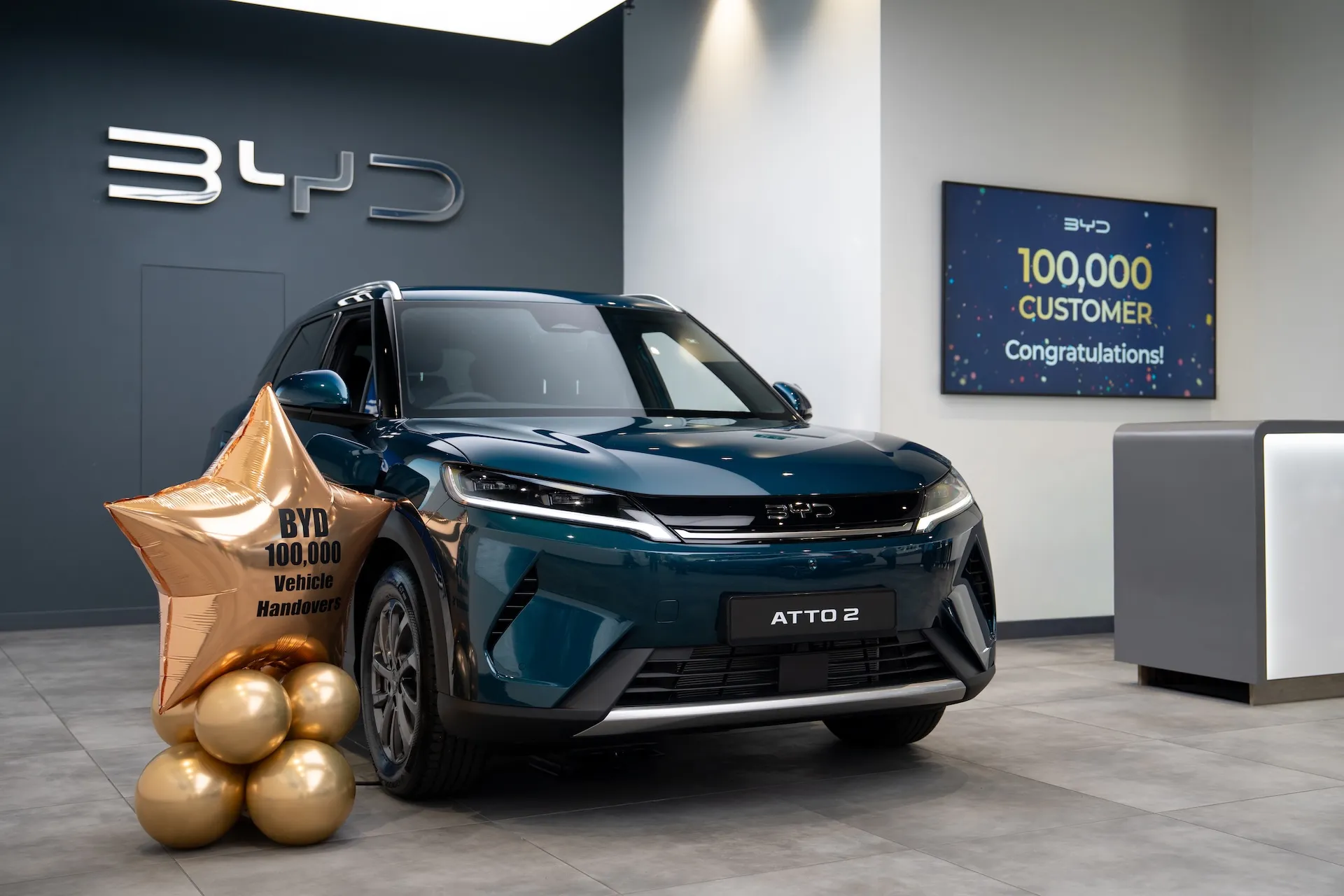 BYD SEALION 7 and DOLPHIN SURF models representing BYD's UK sales milestone of 100,000 registrations
