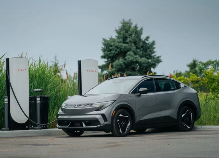 2027 Mitsubishi Eclipse Sportback EV fast-charging at a Tesla Supercharger using its standard NACS port