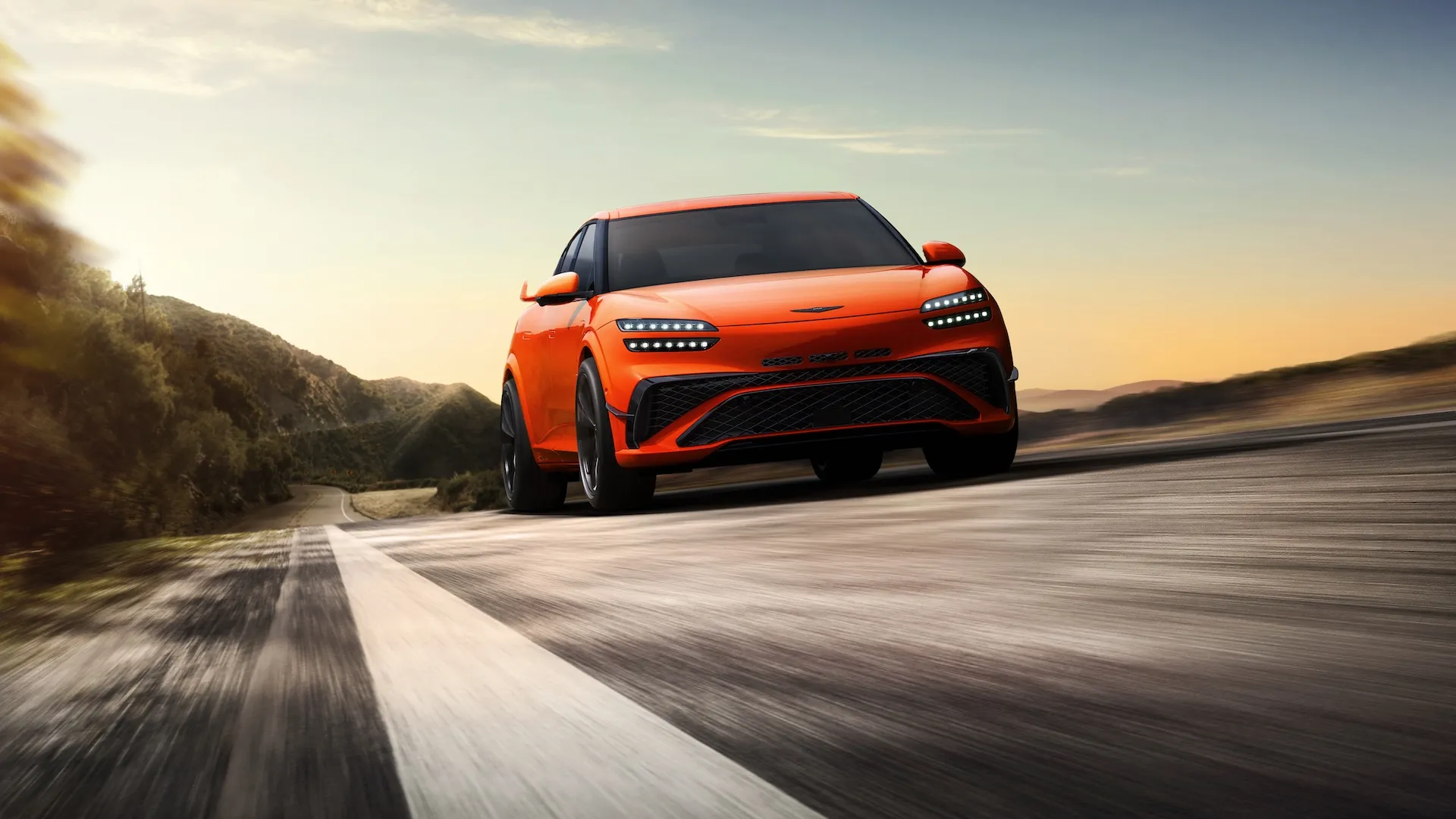 2027 Genesis GV60 Magma high-performance electric SUV shown in Magma Orange with 21-inch forged wheels and winglet-style rear spoiler