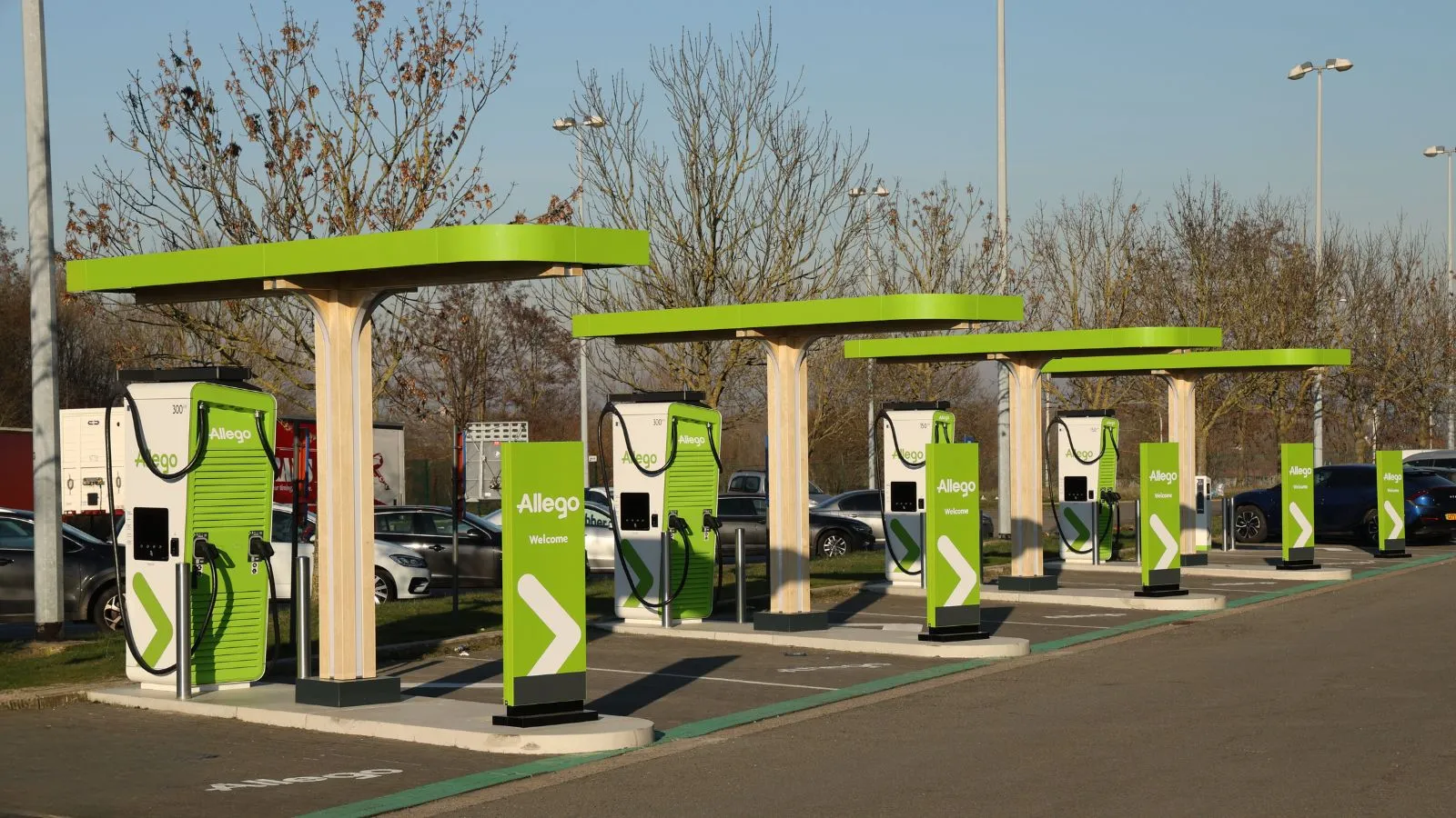 Allego charging hub with multiple green-canopied fast chargers, part of the network moving to the AMPECO platform