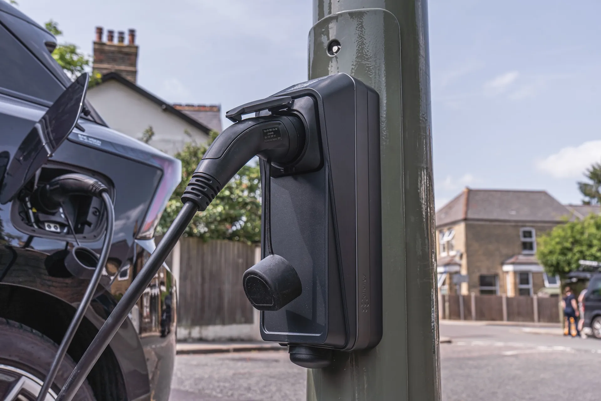 char.gy on-street EV charge point mounted on a lamp column with a charging cable connected to an electric vehicle on a residential street