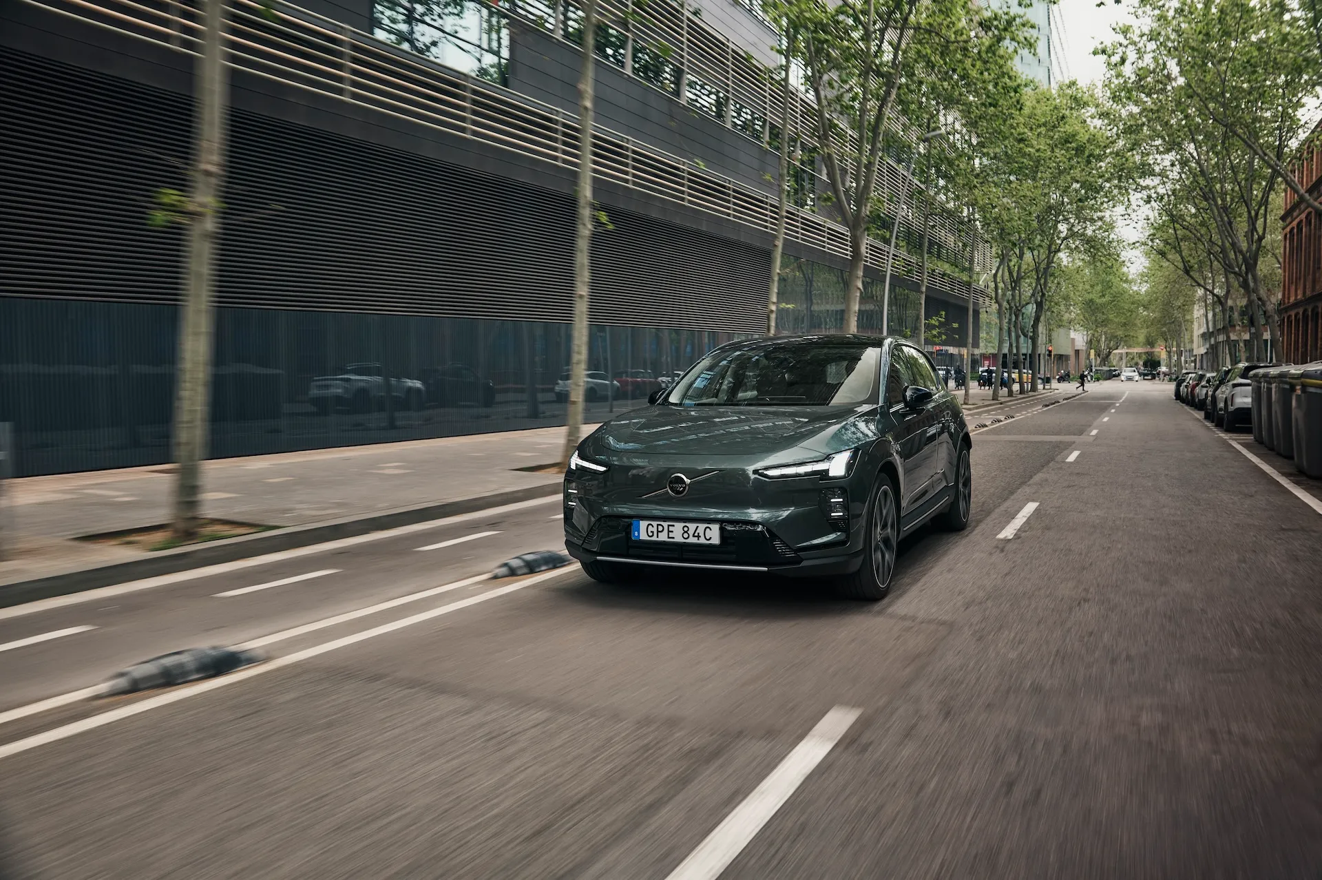 Volvo EX60 electric SUV driving on a city street during first customer deliveries in Sweden