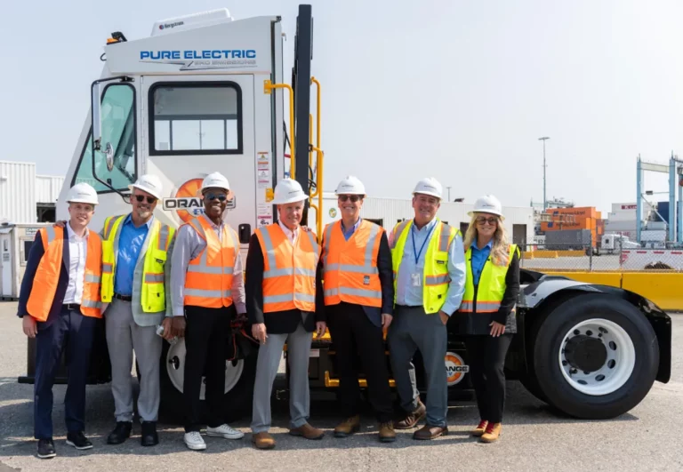 Orange EV and APM Terminals team members standing alongside an Orange EV electric terminal truck at Port Elizabeth