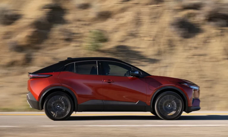 2027 Toyota C-HR compact electric SUV in Tandoori with Midnight Black Metallic roof, shown in profile on a mountain road