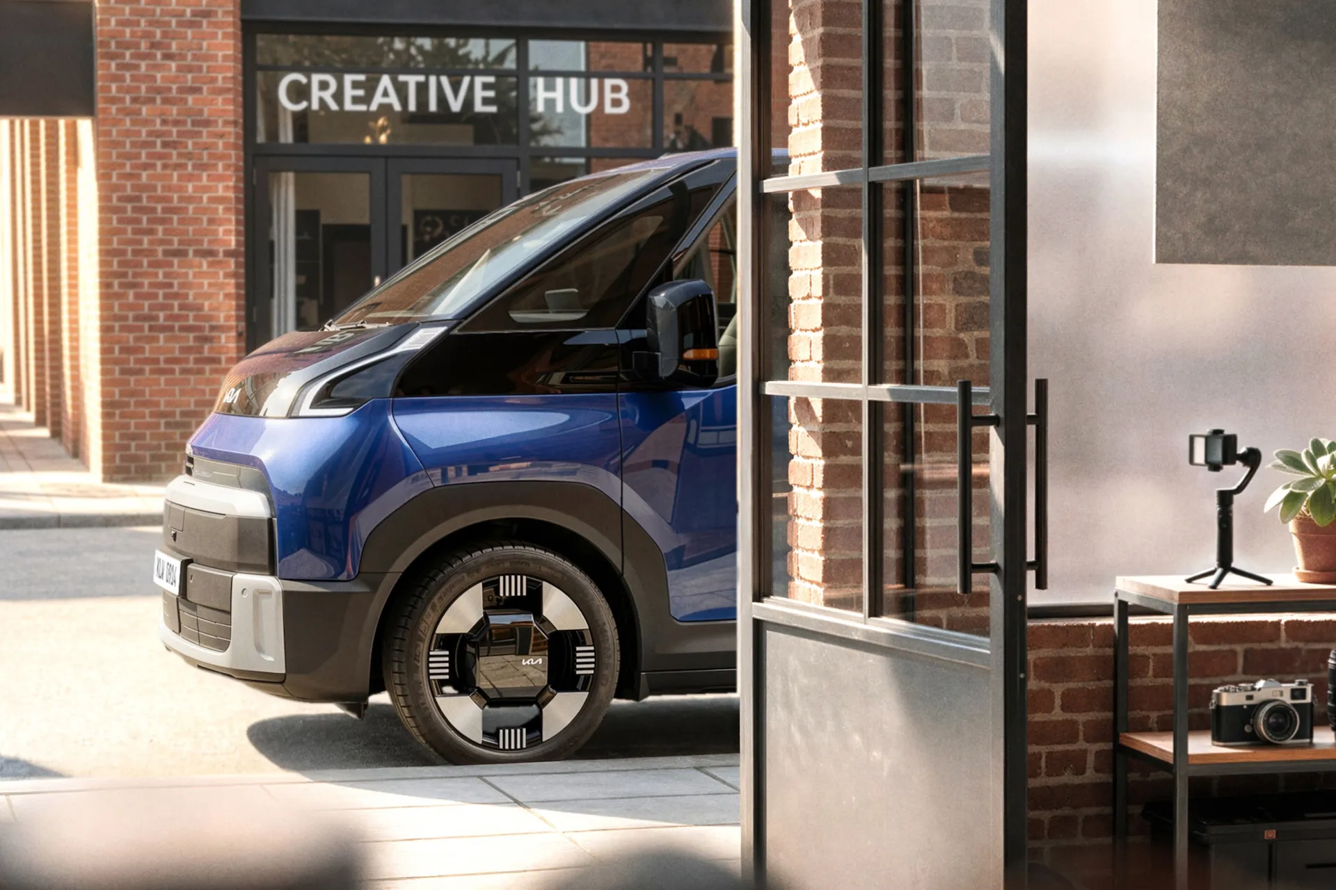 Kia PV7 electric light commercial vehicle shown in teaser image with one-box profile, black hood and pillar garnish