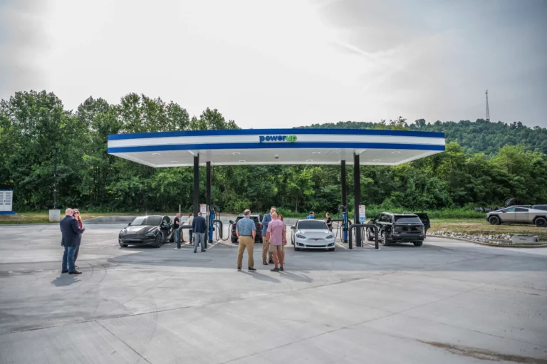PowerUp America DC fast charging station canopy with electric vehicles charging at multiple dispensers
